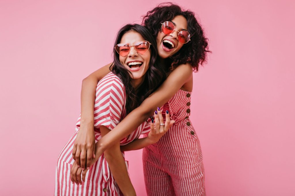 Two young Greensboro NC woman laughing and hugging before OBGYN appointment